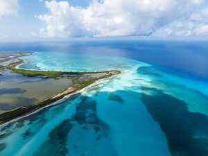 vista aerea de la isla de Cozumel con aguas cristalinas en 2 tonos de azul